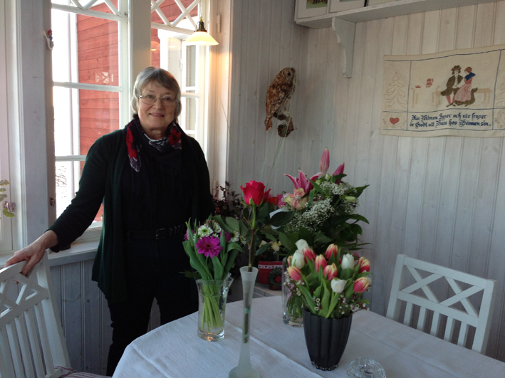 Karin Johansson på sin veranda bland blomstren. 